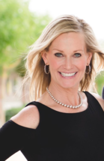 Smiling woman outdoors wearing black top.