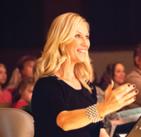 Smiling woman gesturing during event.