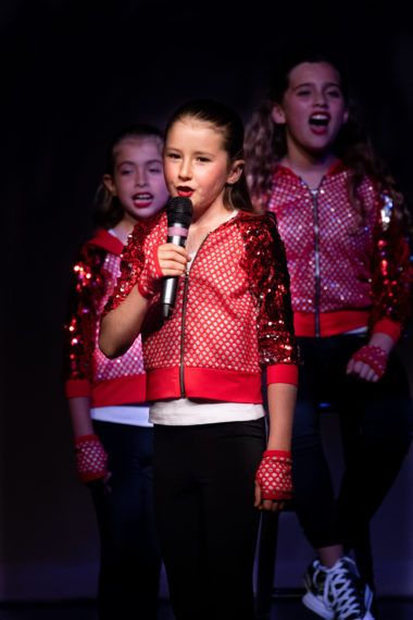 girl singing wearing red jacket